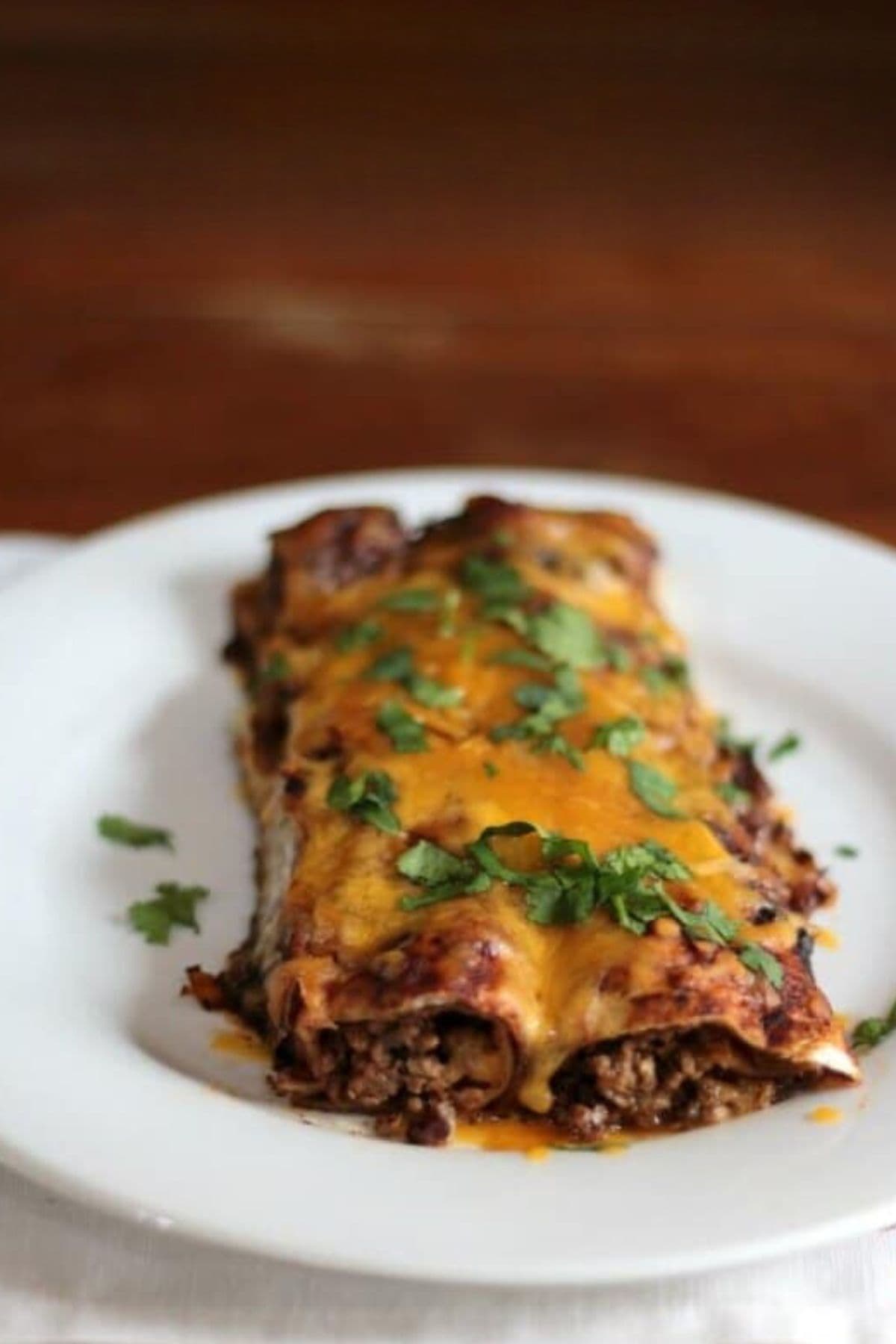 Beef enchiladas on a white plate.