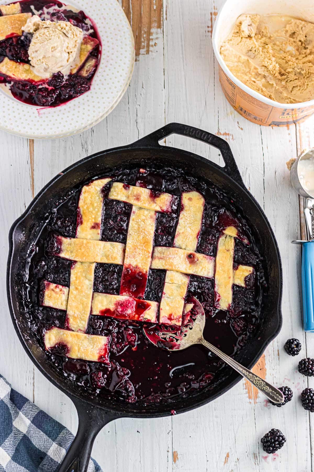 Blackberry cobbler with pie crust in a cast iron skillet.