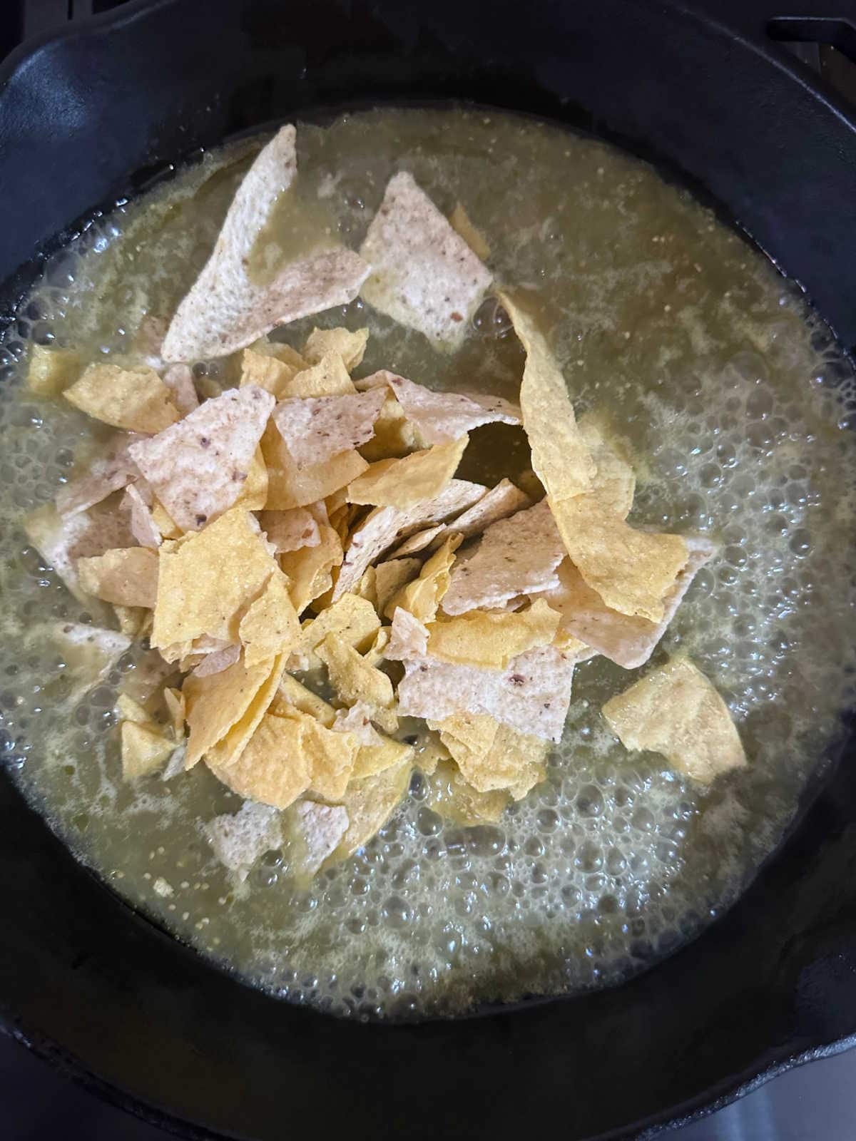 Stirring the tortilla chips into the salsa.