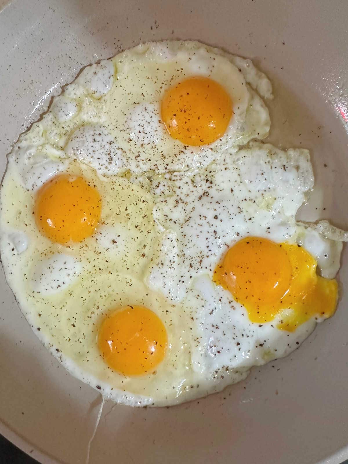 Frying the eggs in a pan.