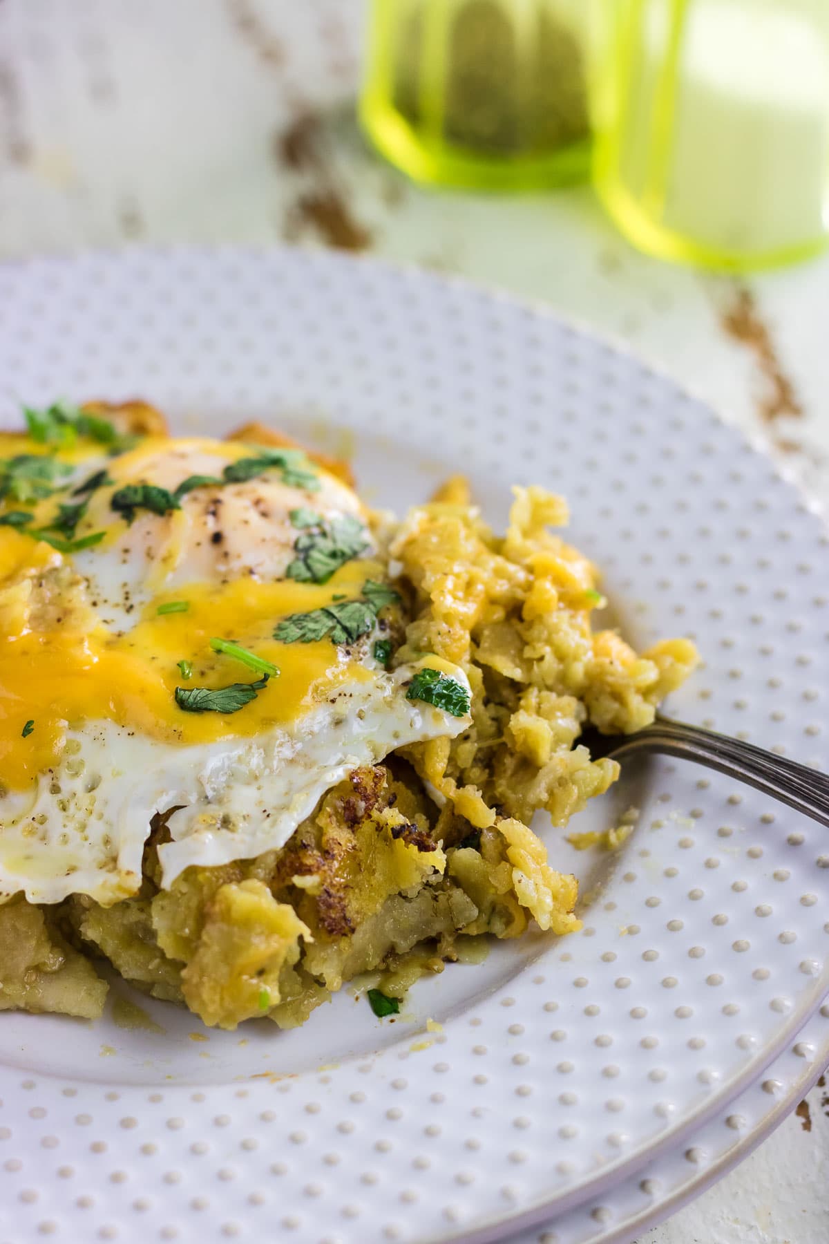 A close-up of easy green chilaquiles on a plate with a fork.