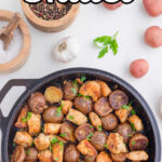 Overhead view of an iron skillet filled with cooked garlic butter chicken and potatoes with title text overlay for Pinterest.