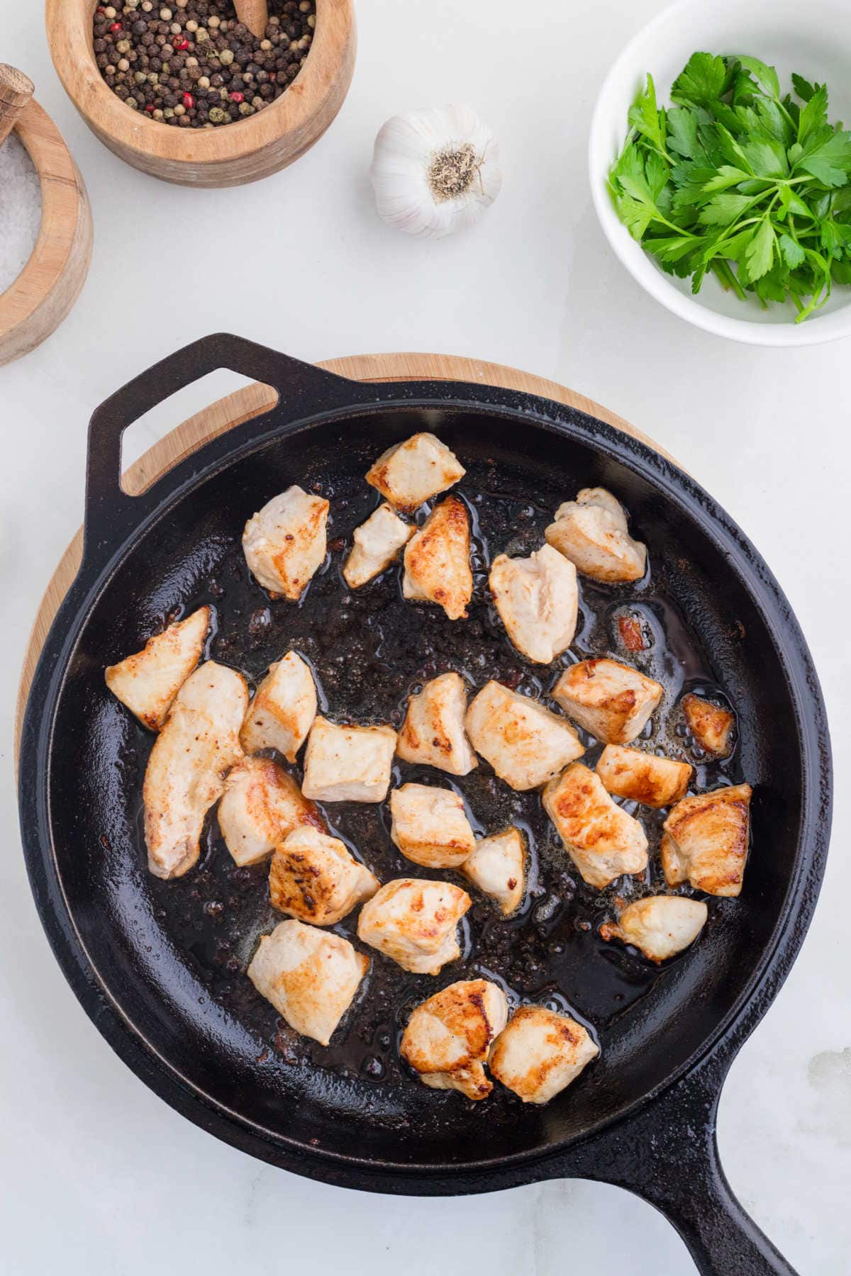 Cooking the chicken pieces in a skillet.