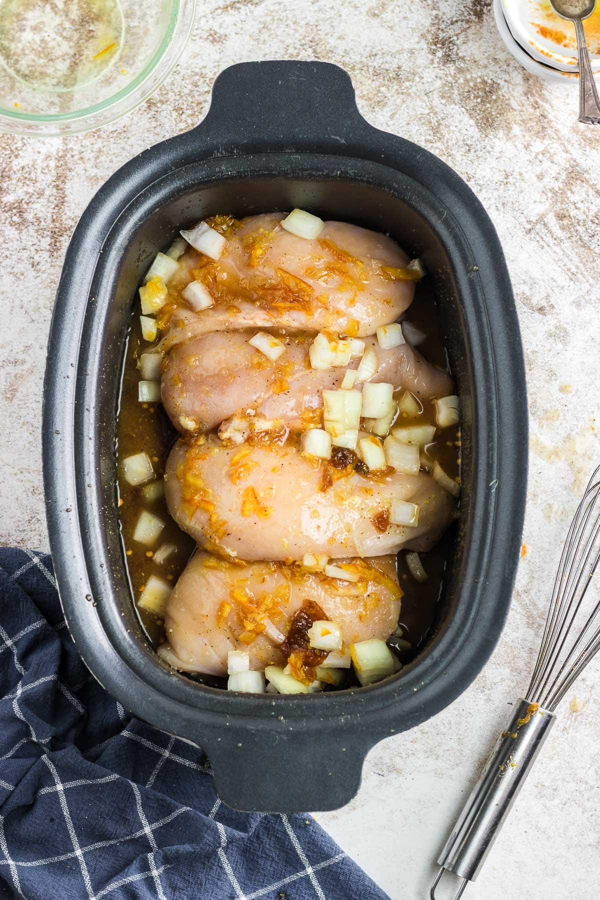 Marinade ingredients poured over the chicken.