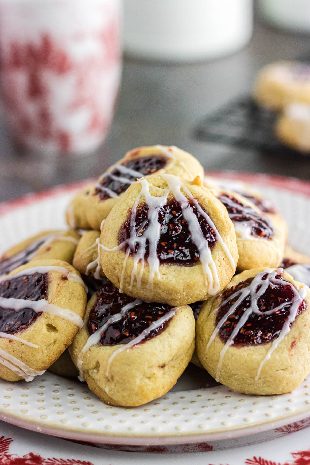 An up-close photo of raspberry jam thumbprint cookies on a plate.