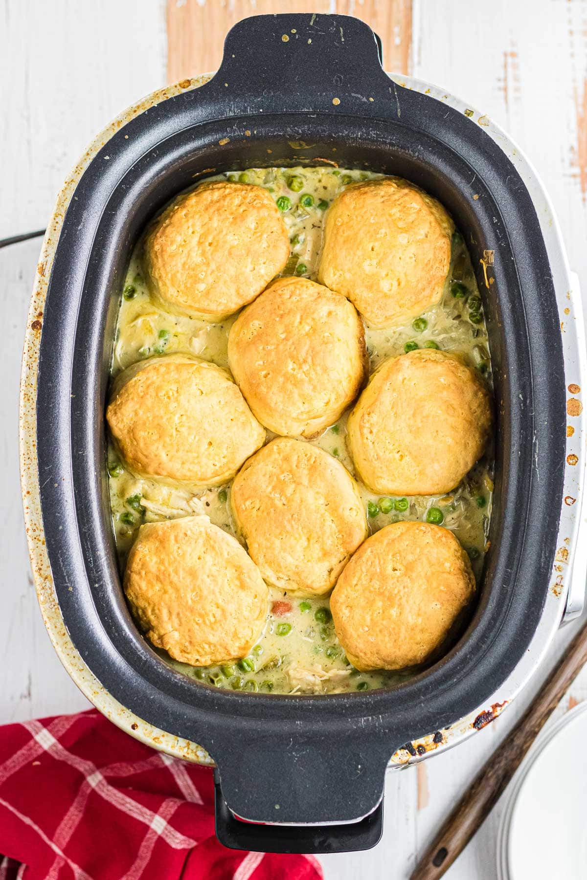 Cooked biscuits placed on top of the chicken pot pie mixture in the slow cooker.