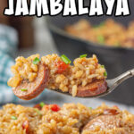 A spoonful of jambalaya being lifted from the plate with a title text overlay for Pinterest.