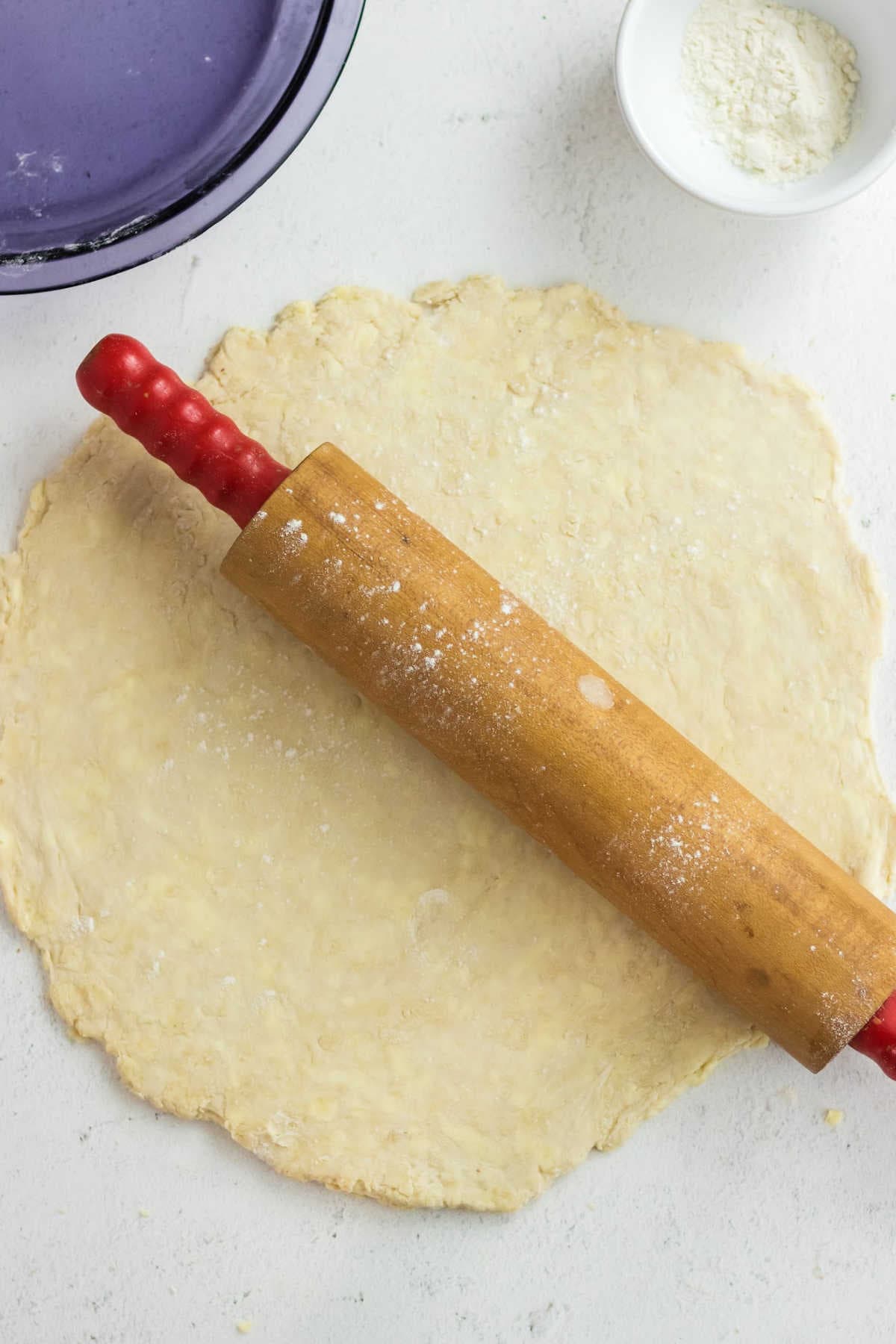 Dough rolled out with a rolling pin on top.