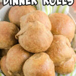 Closeup of golden brown whole wheat dinner rolls with a title text overlay for Pinterest.
