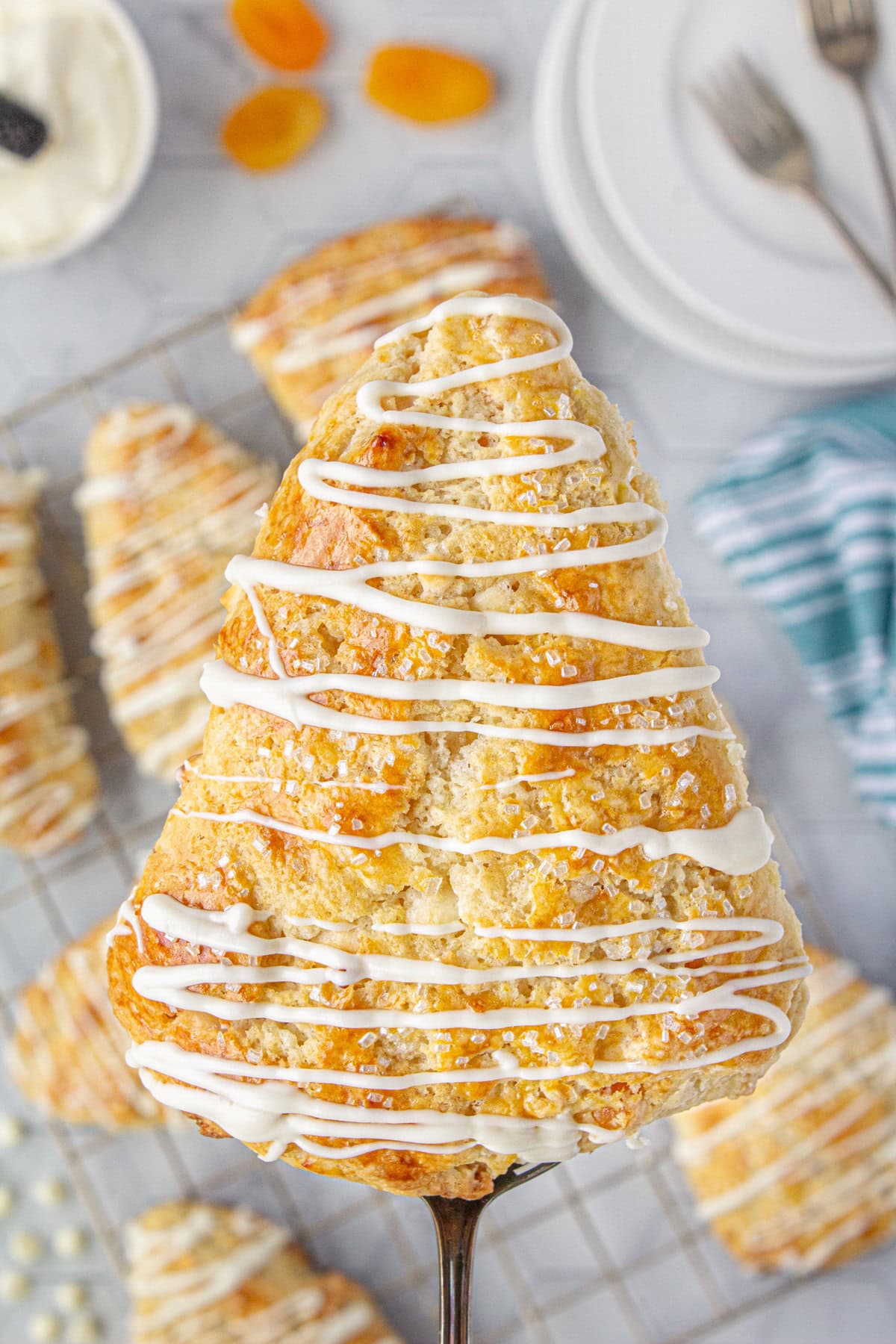 An up-close view of an apricot white chocolate scone with white chocolate drizzle.