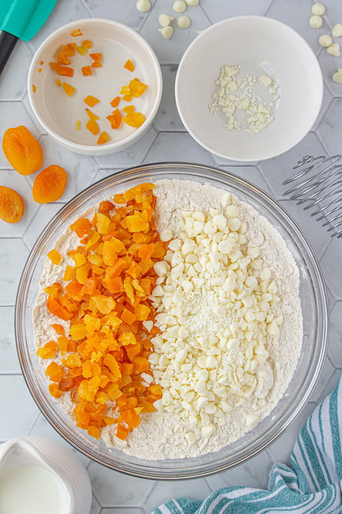 Adding the white chocolate chips and apricots to the scone mixture.