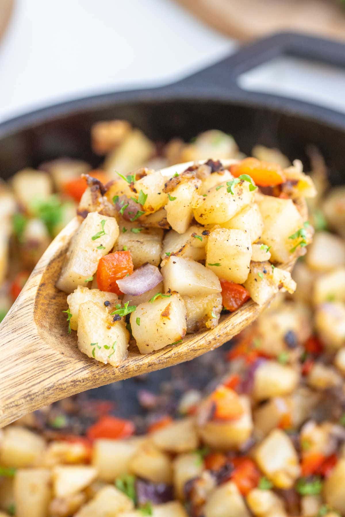 Potatoes being served with a wooden spoon.