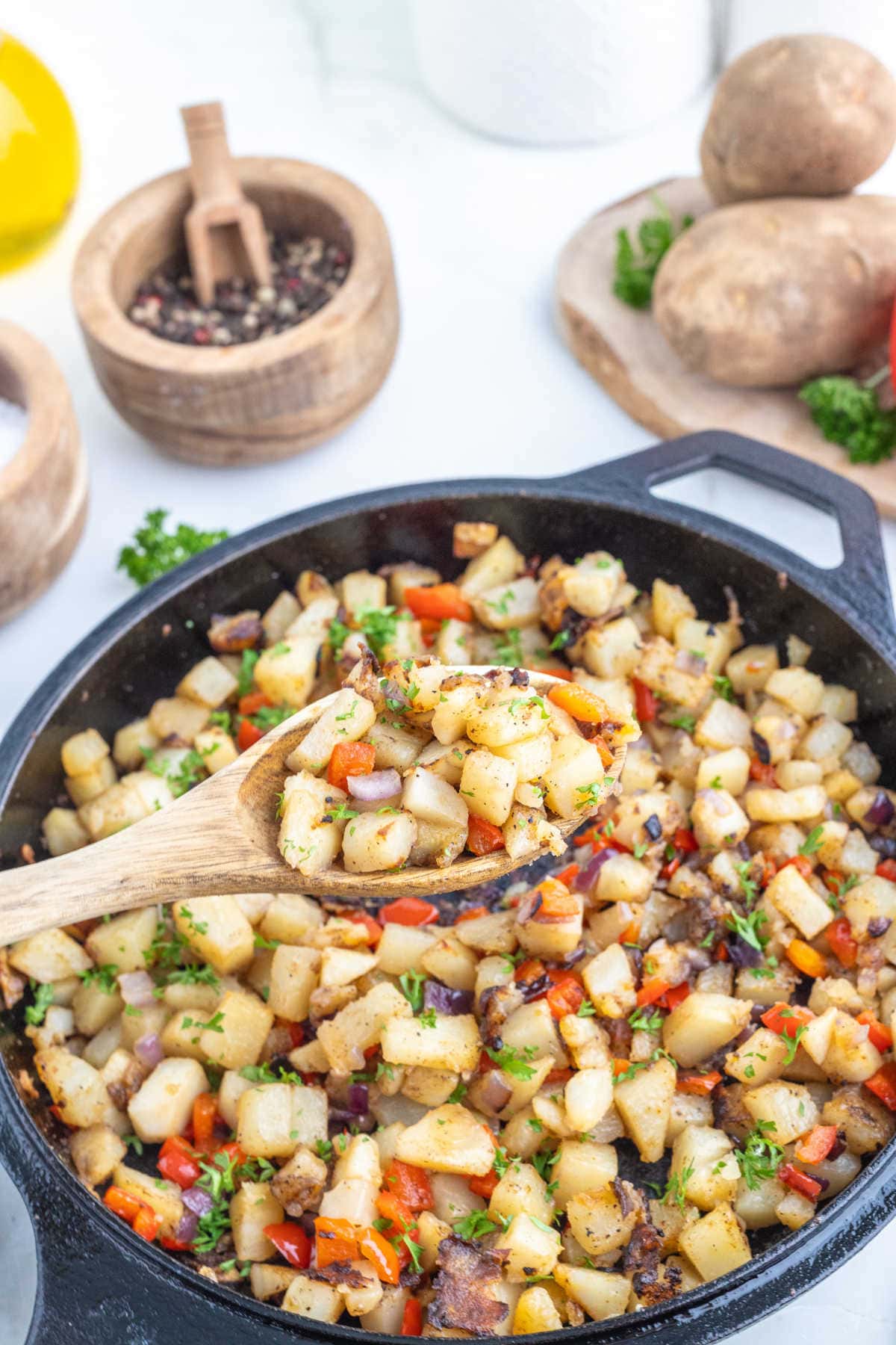 Country potatoes with peppers in a cast iron skillet.