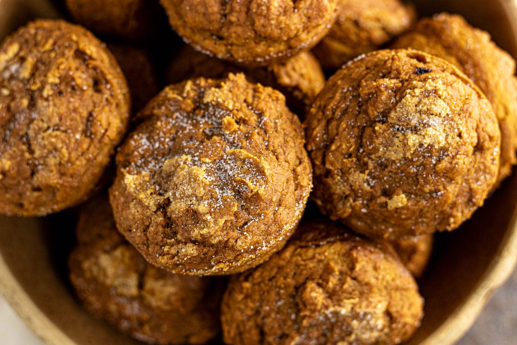 Closeup of baked pumpkin muffins topped with a sprinkle of sugar.