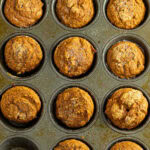 Overhead view of finished muffins in a muffin tin with title text overlay for Pinterest.