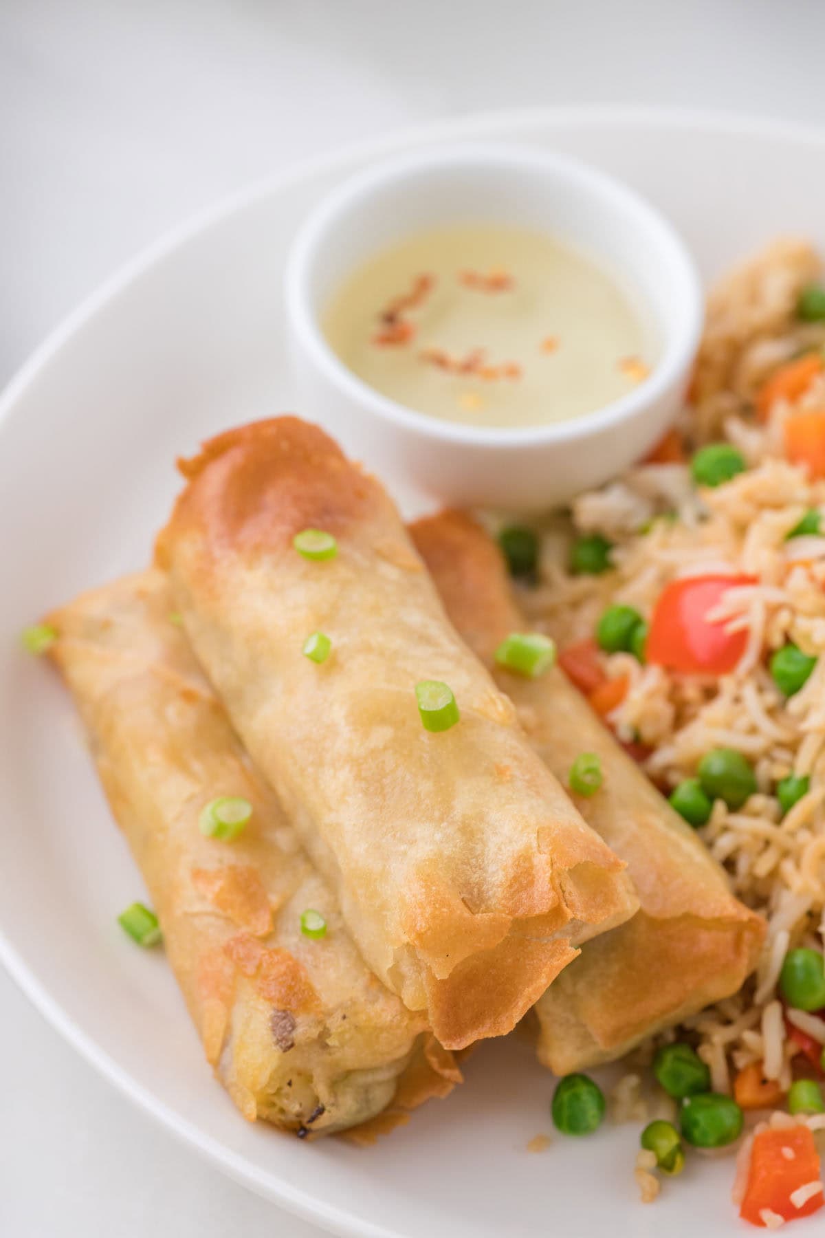 Finished spring rolls on a plate with rice.