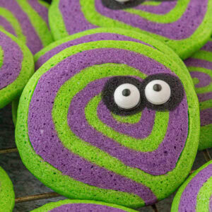 Closeup of purple and green swirled Beetlejuice Halloween cookies with eyes.