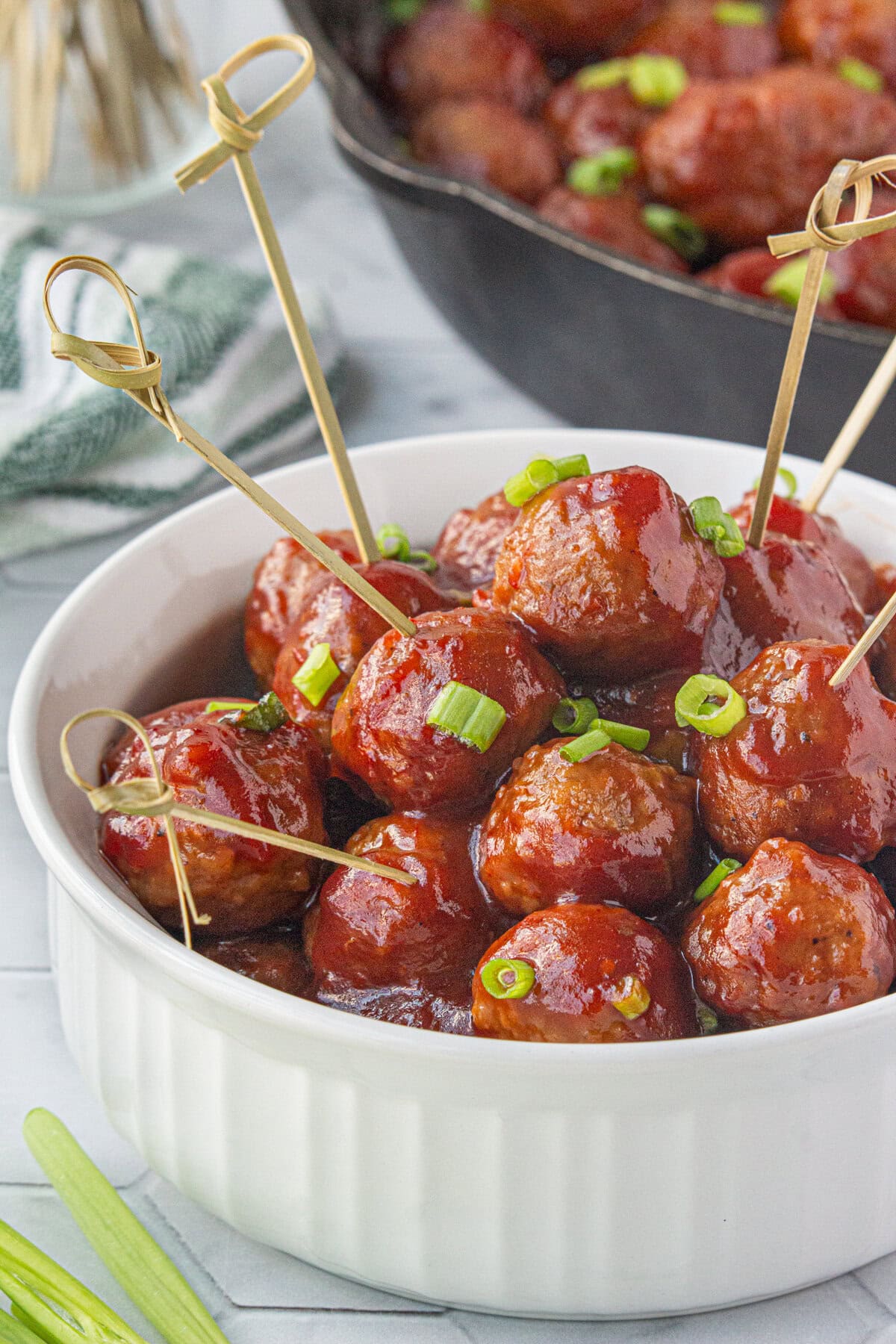 Cranberry sauce meatballs in a serving bowl with toothpicks.