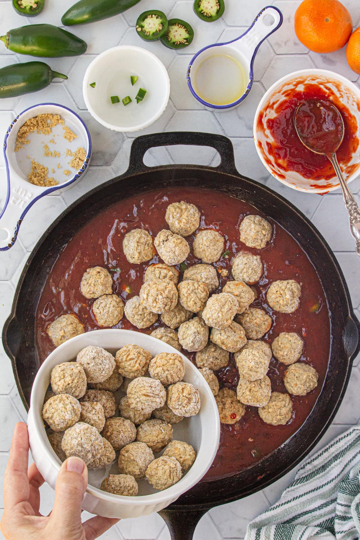 Adding the thawed meatballs to the cranberry sauce.