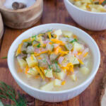 A bowl of dill pickle soup on a table.