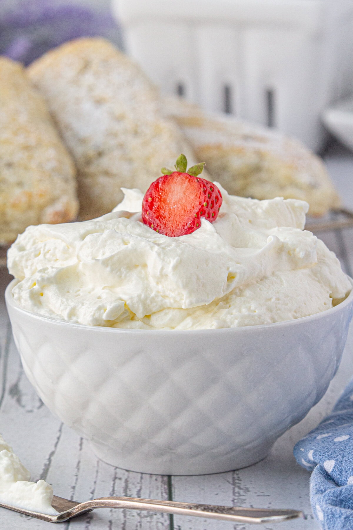 A bowl filled with mock clotted cream and a strawberry on top.