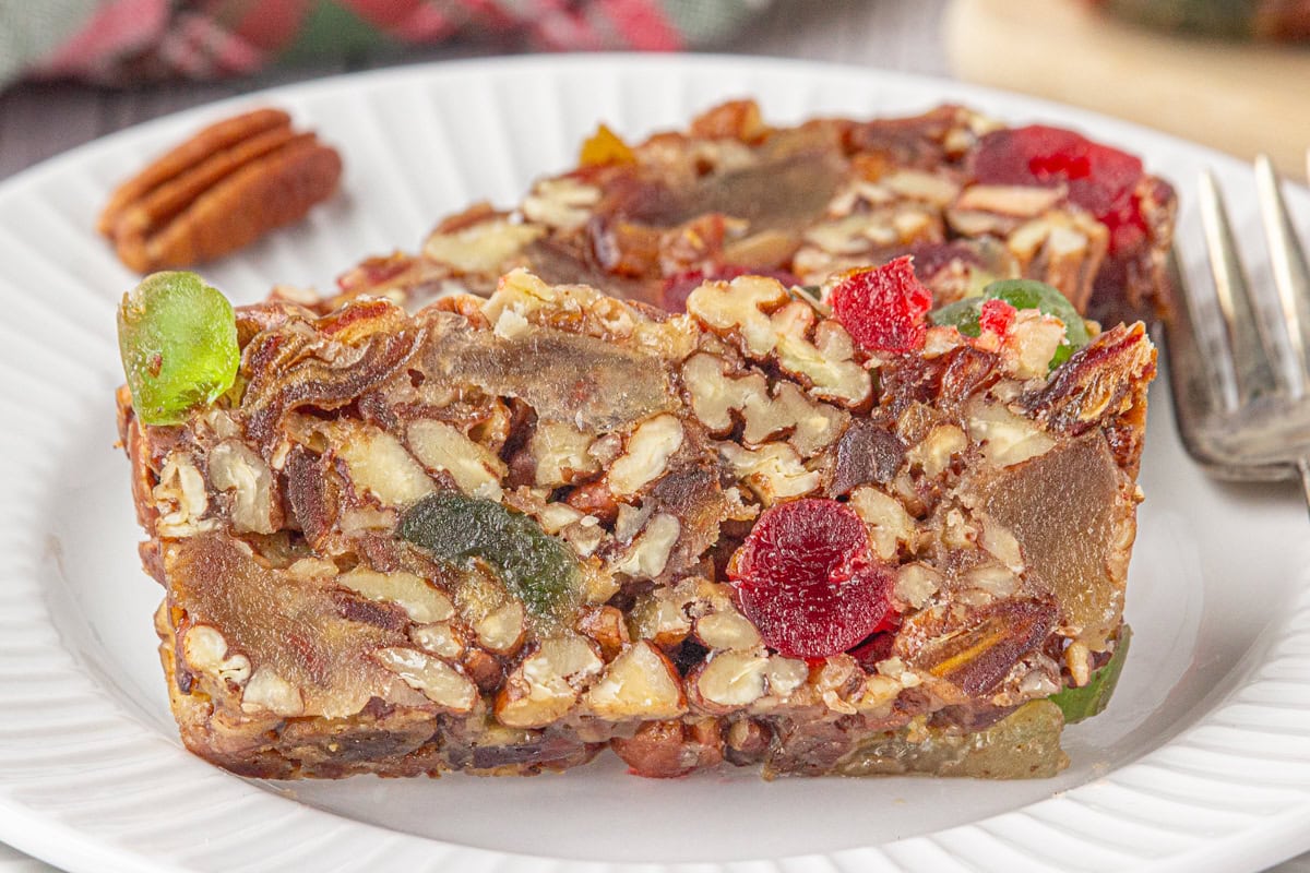 Closeup of a slice of fruitcake on a plate.