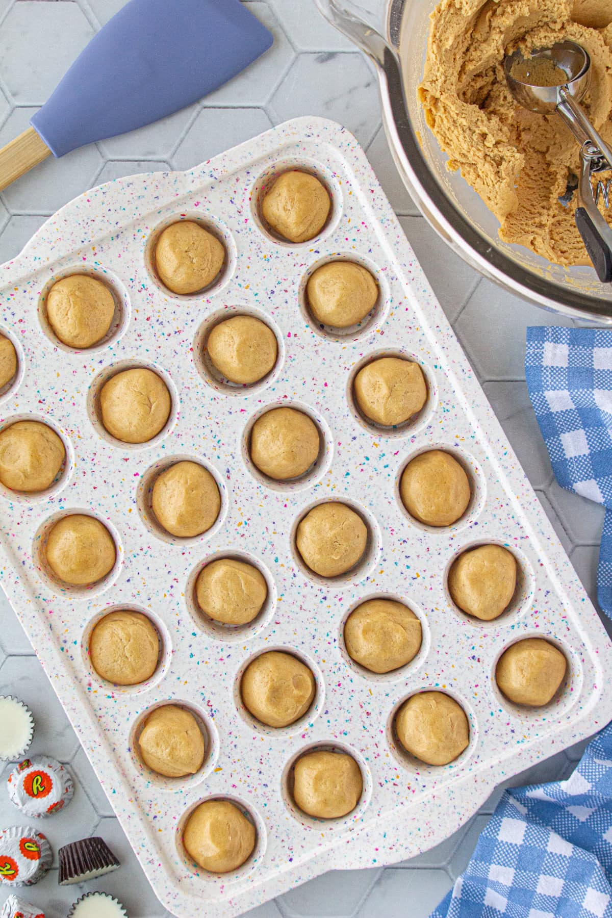 The cookie dough shaped into balls and placed in a mini muffin tin.