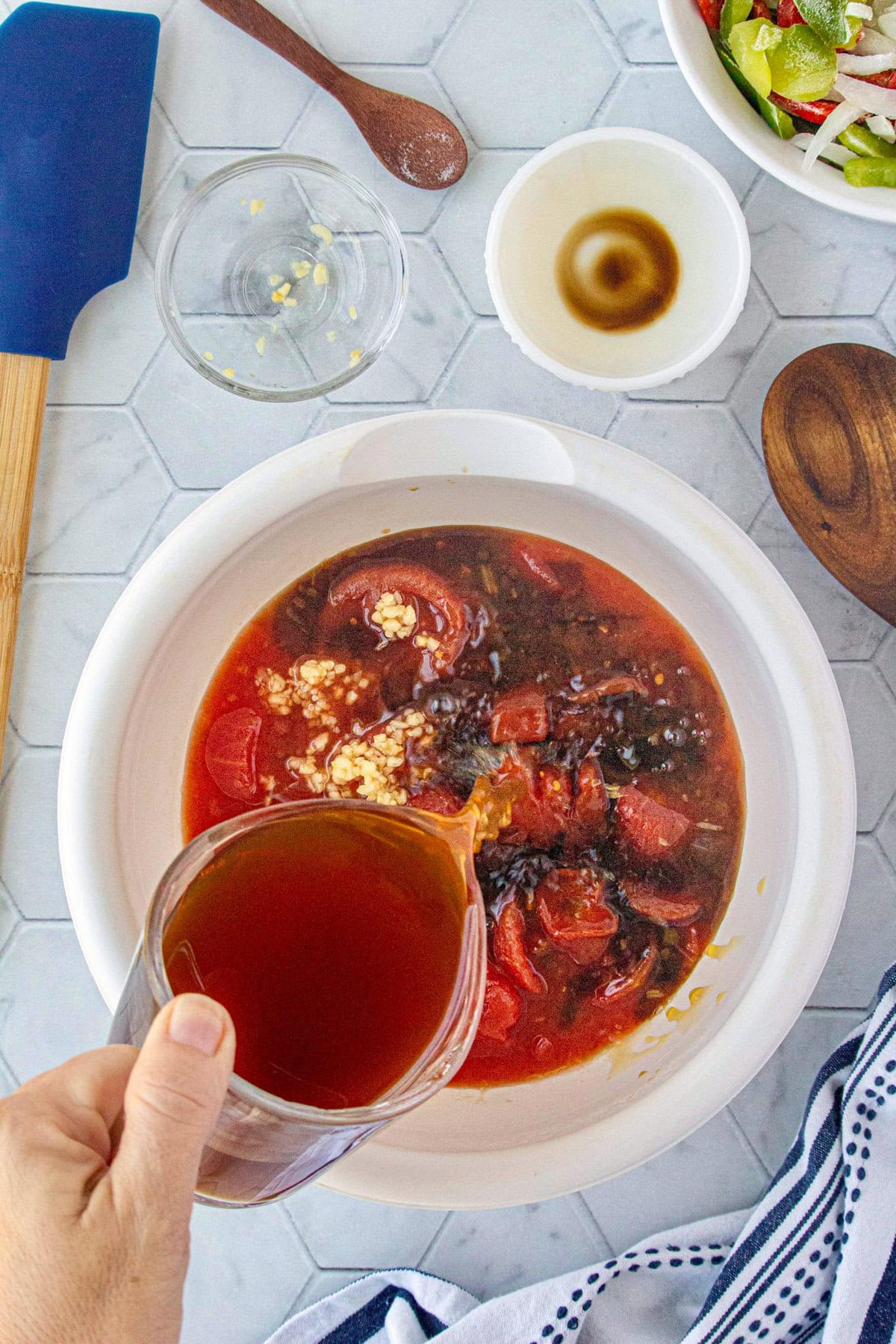 Adding the beef stock to the other liquid ingredients.