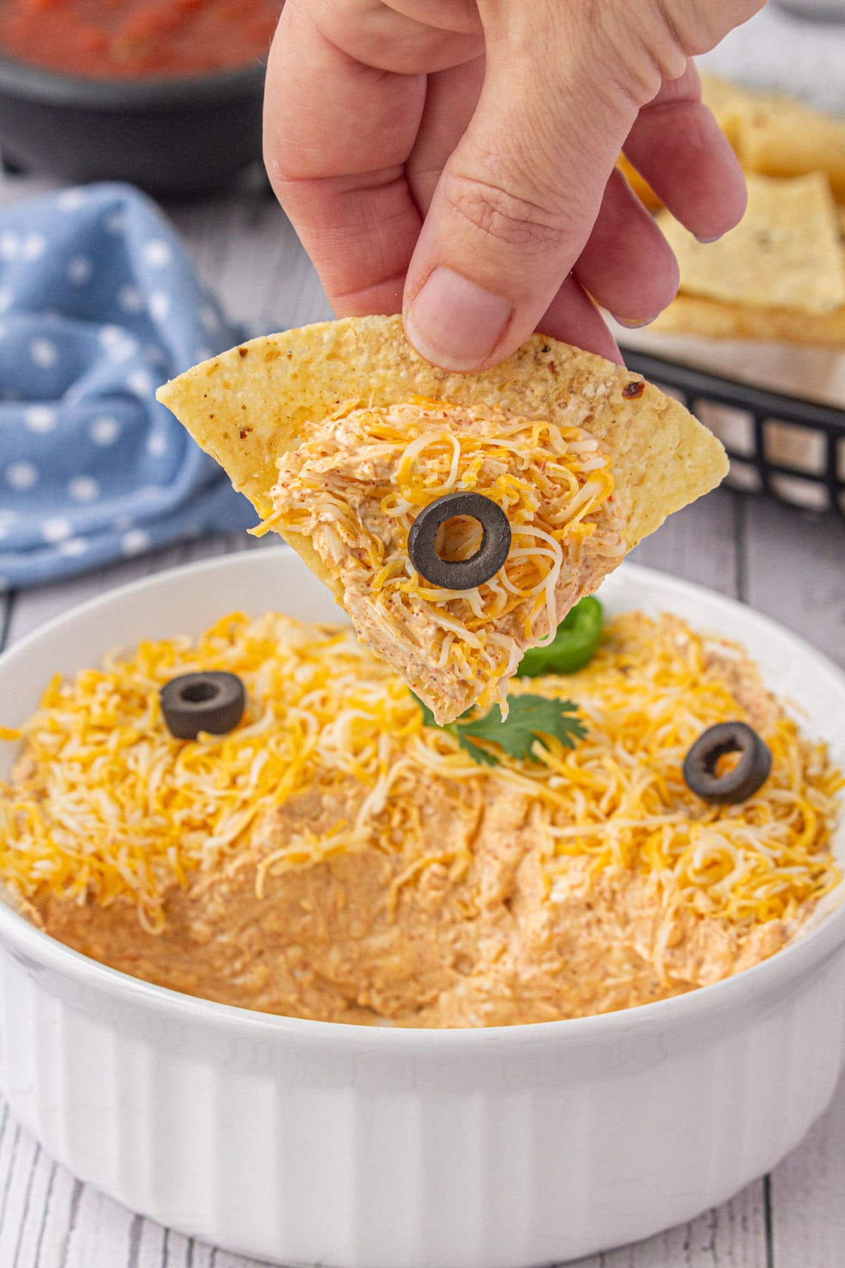 Scooping up the 4-ingredient taco dip with a tortilla chip.