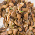 Overhead view of caramelized onions and mushrooms in a pan with a title text overlay for Pinterest.