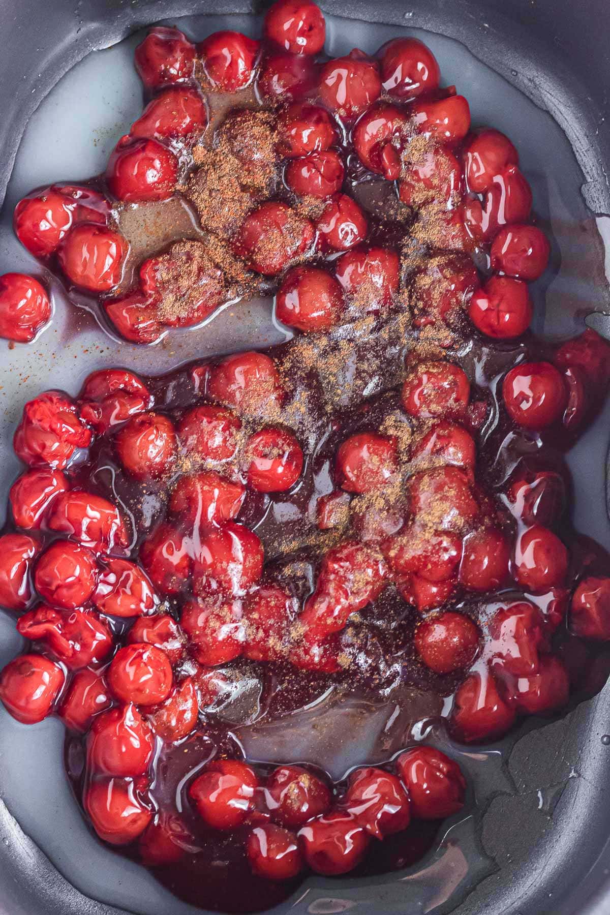 Cherry pie filling, lemon juice, and seasonings added to the slow cooker.