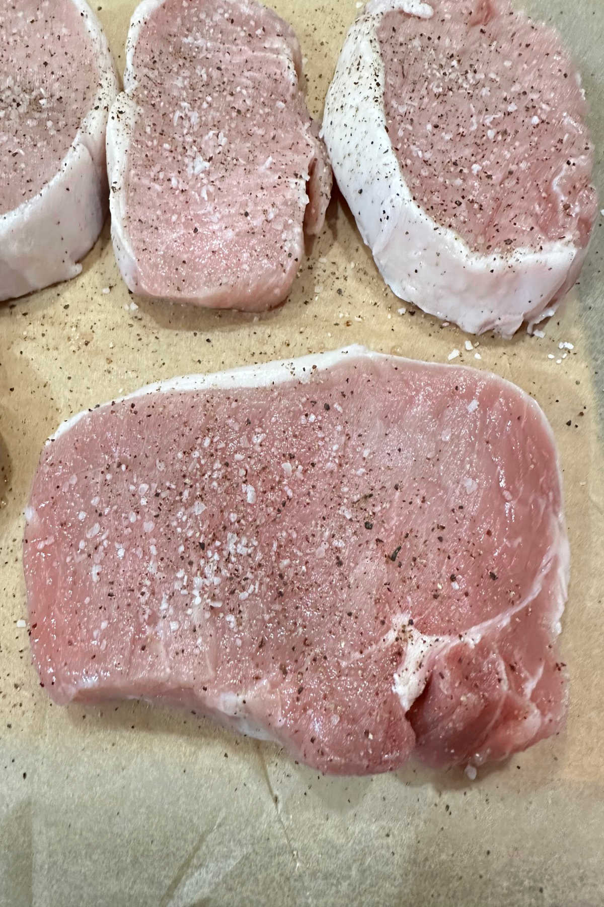 Pork chops seasoned with salt and pepper.