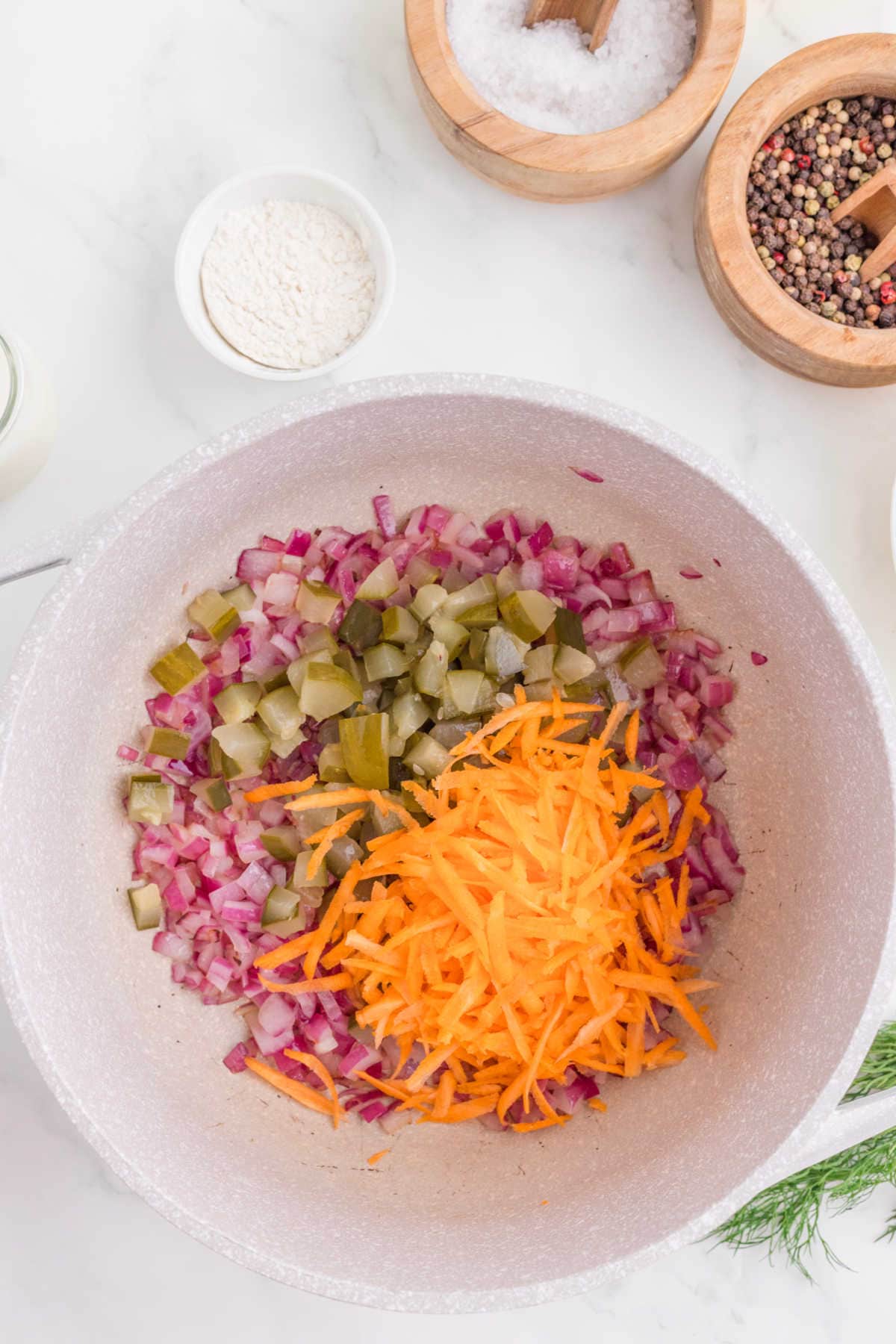 Onions, pickles, and carrots in a pan.