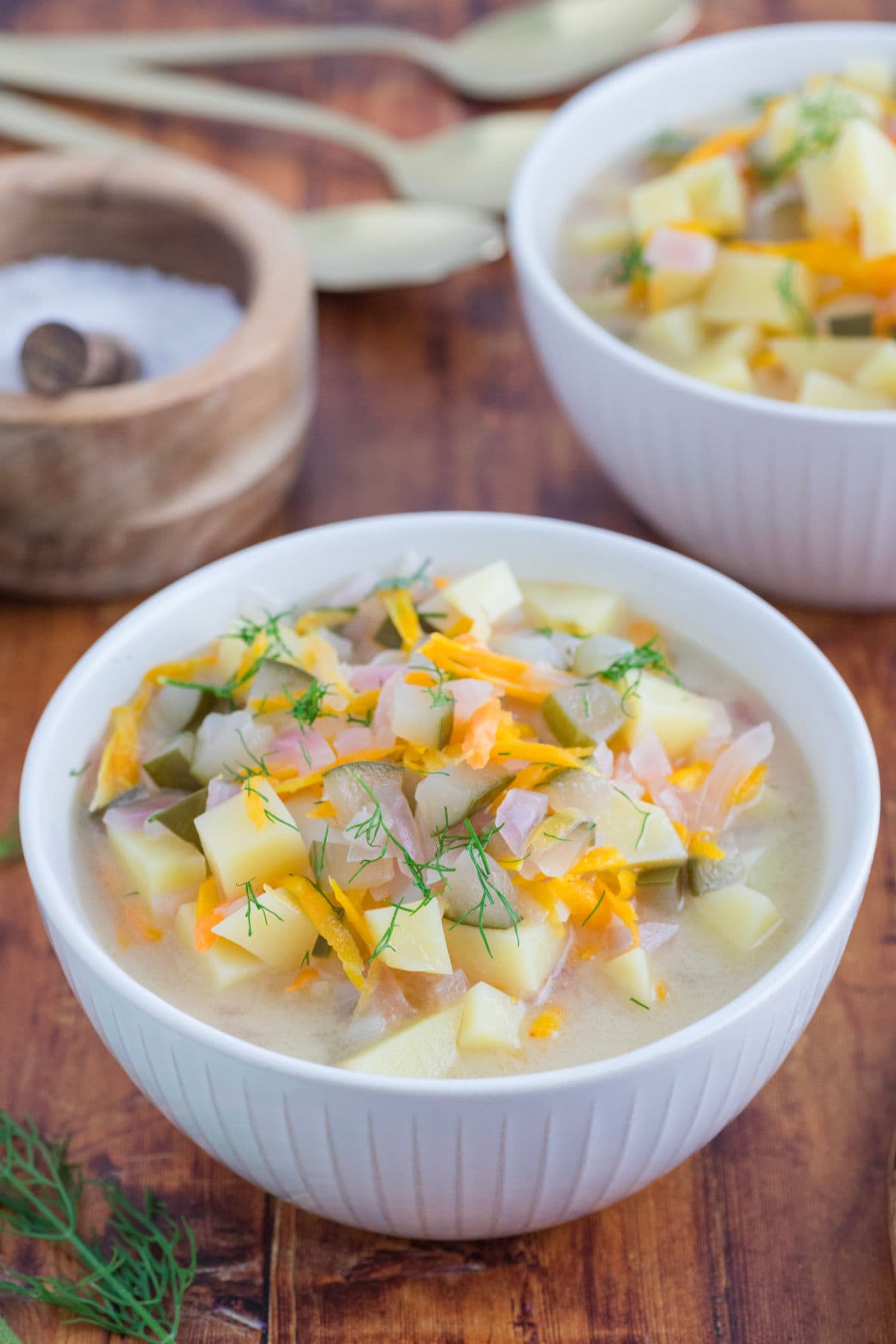 Bowls of dill pickle soup on a table.