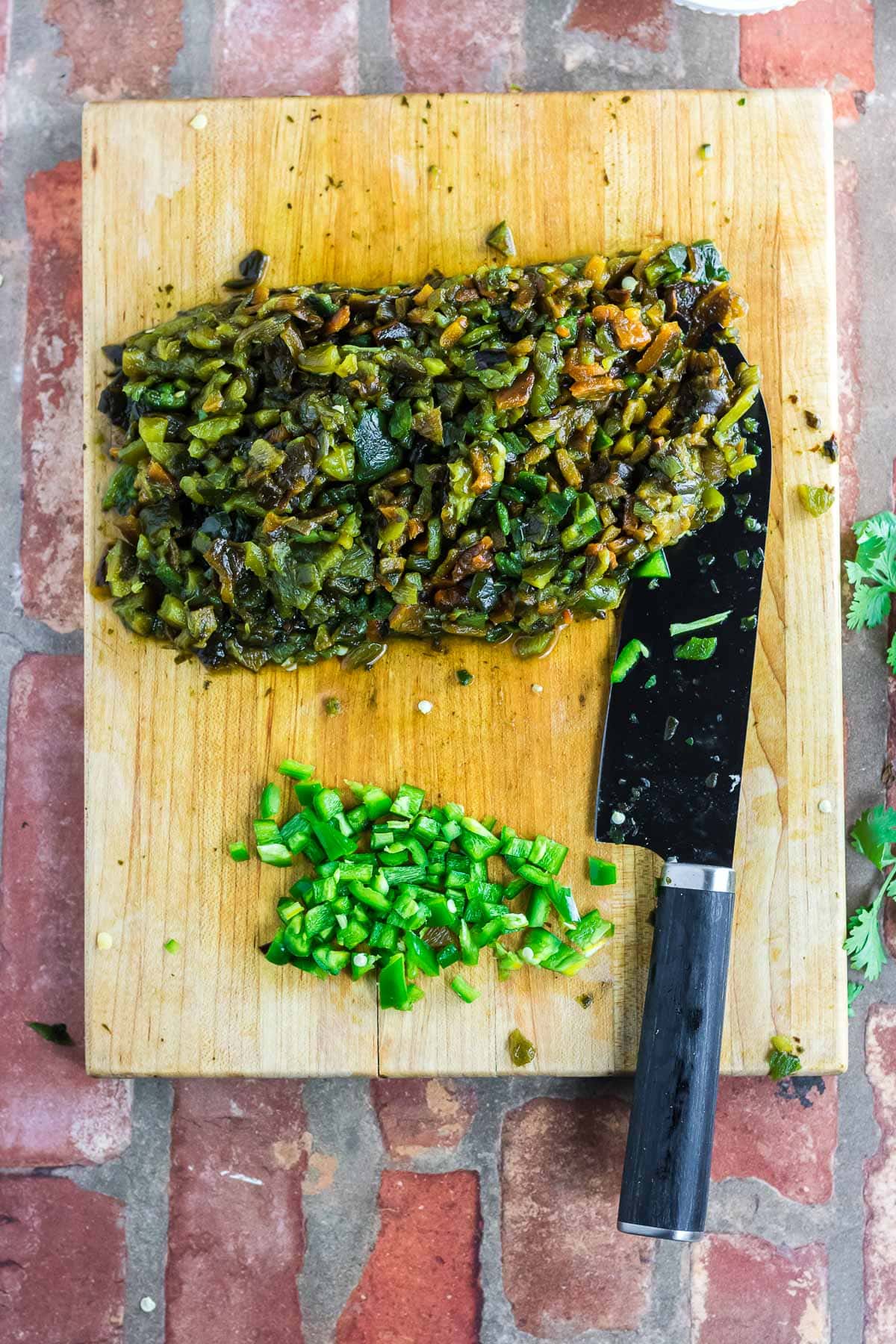 Chopping the jalapenos and the roasted/peeled poblano peppers on a cutting board.