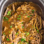 Overhead view of french onion pot roast in the slow cooker with title text overlay for Pinterest.