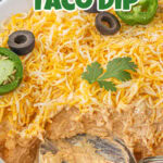 Closeup of taco dip in a casserole dish with title text overlay for Pinterest.