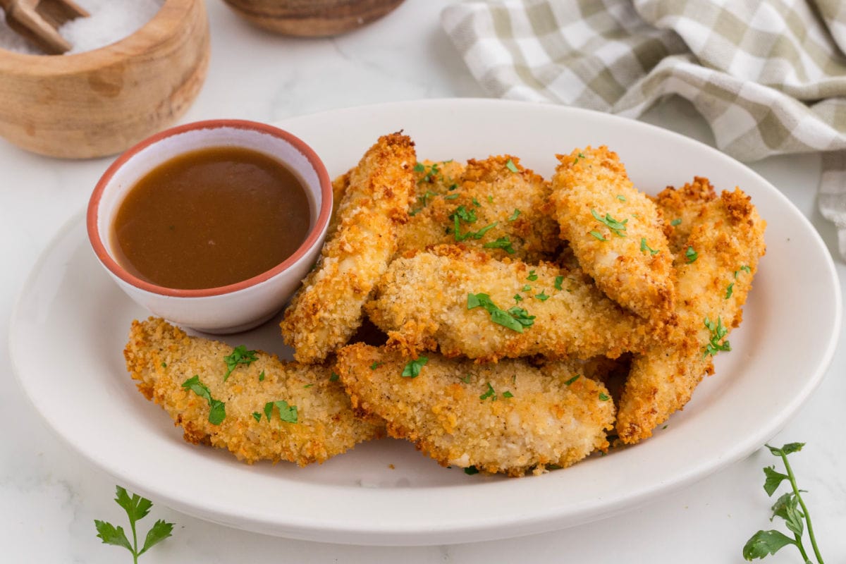 Finished chicken tenders on a plate.