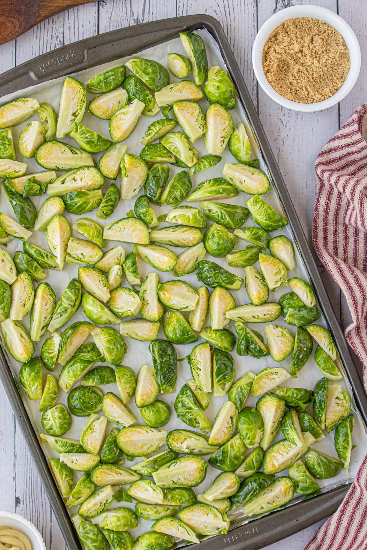 The oiled and salted Brussels sprouts on a baking sheet.