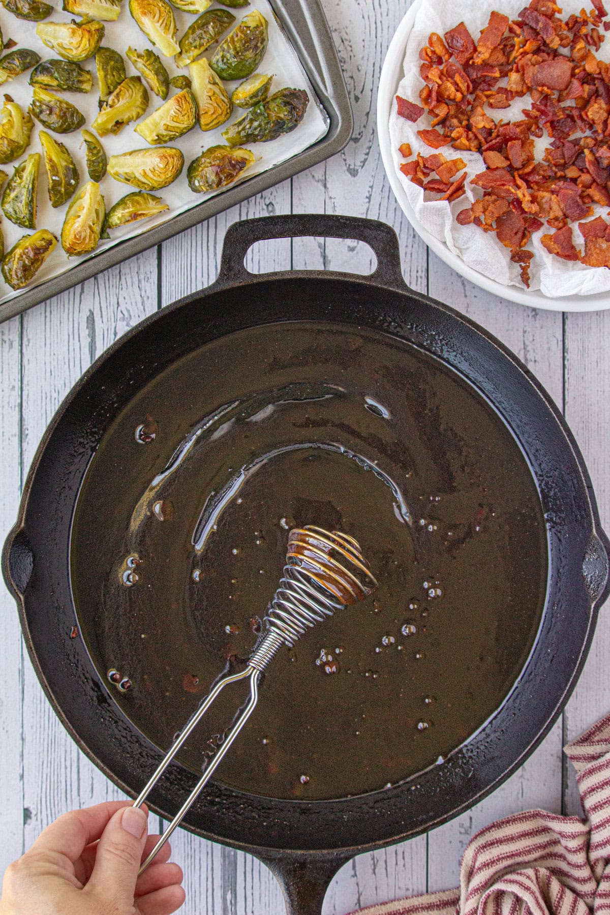 Whisking the dressing together in the skillet.