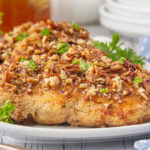 Close-up of honey pecan chicken on a white plate.