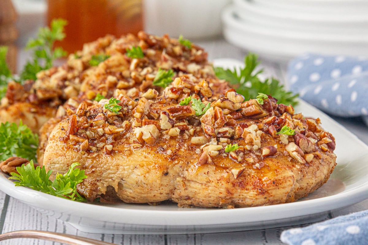 Close-up of honey pecan chicken on a white plate.