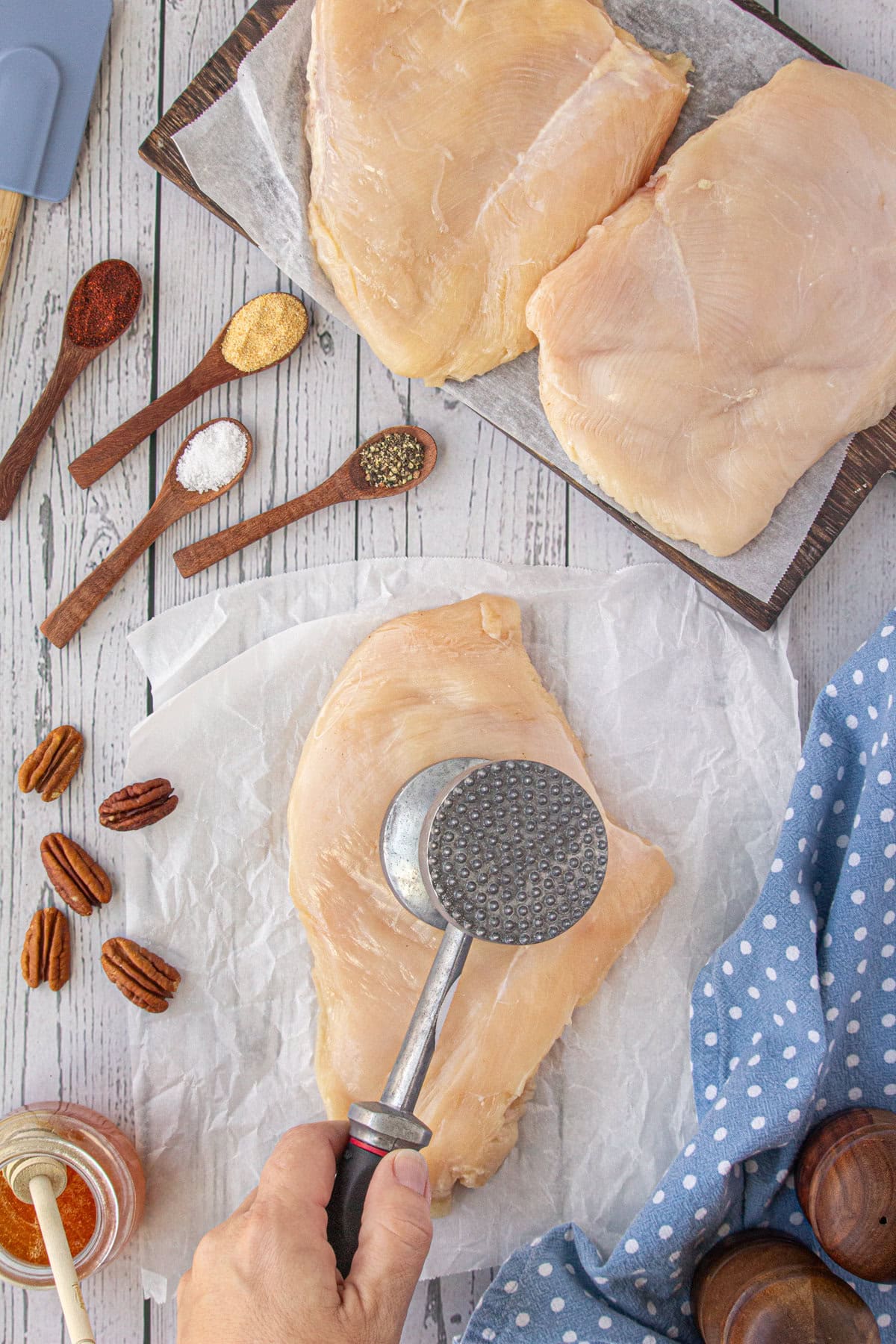 Flattening the chicken breasts with a meat mallet.