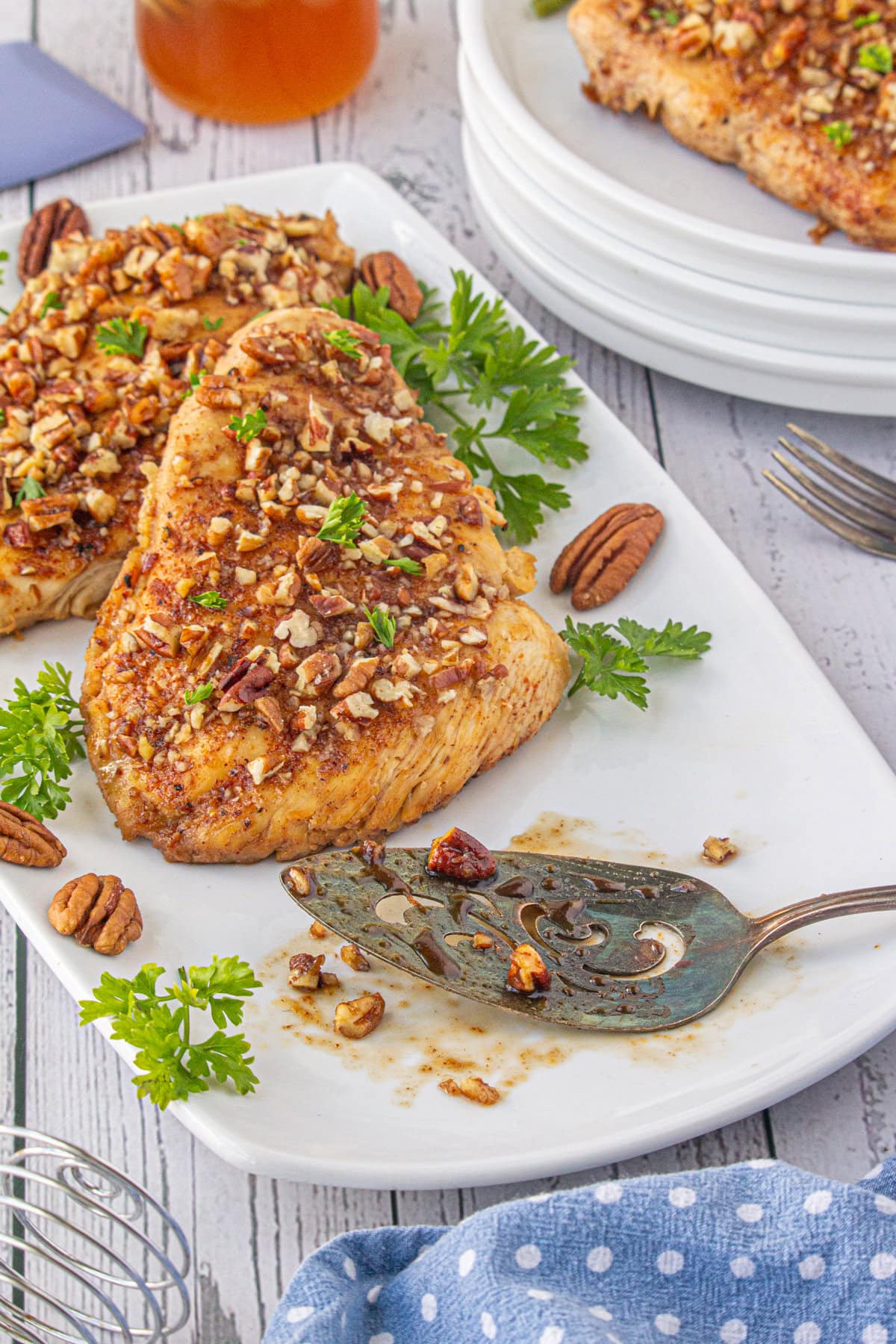 A close-up photo of honey pecan chicken breasts on a serving plate.