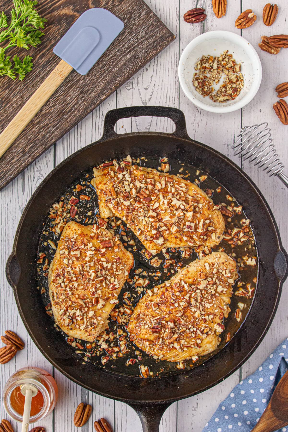 Pecans sprinkled on top of the honey chicken breasts.