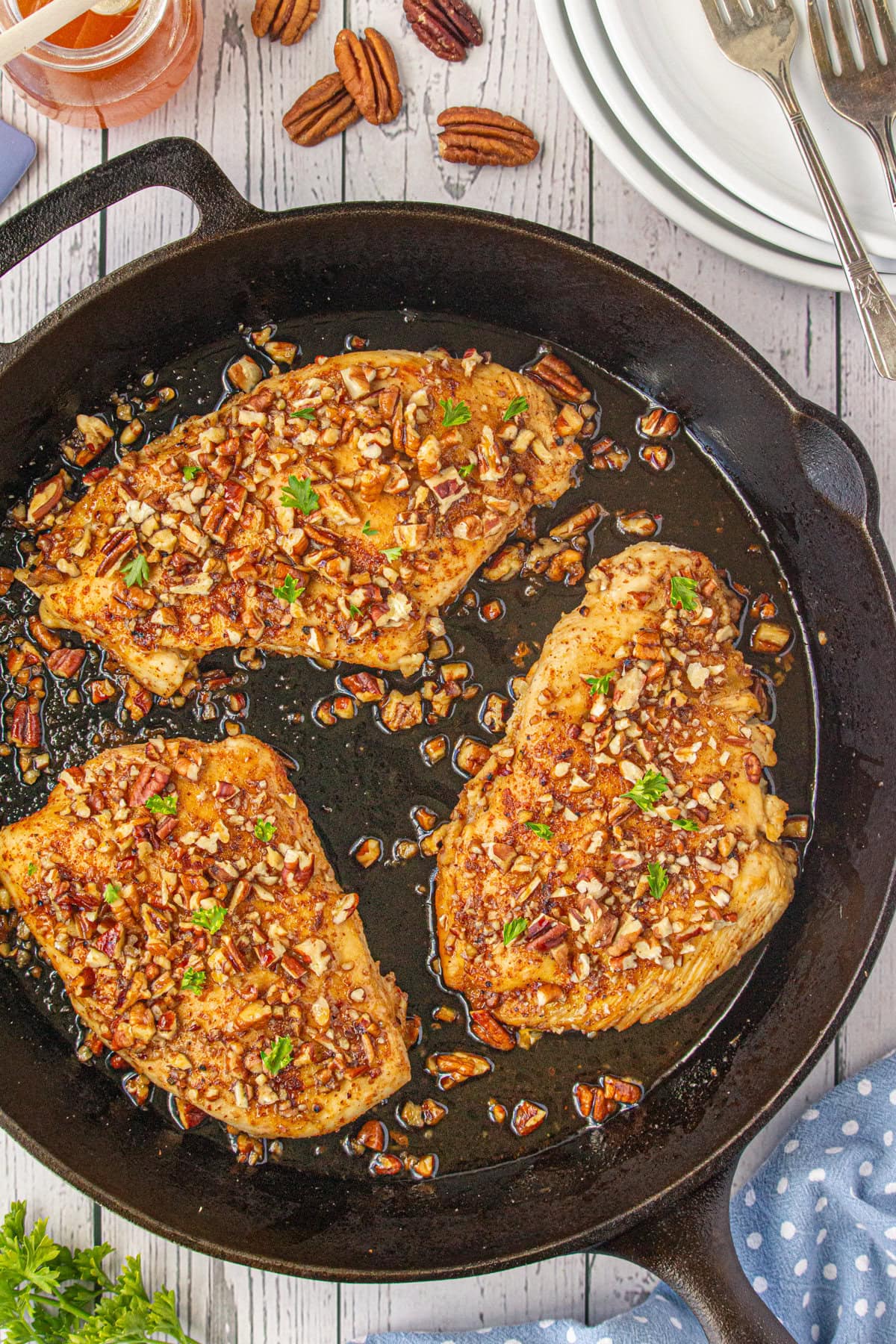 An overhead view of honey pecan chicken breasts in the skillet.