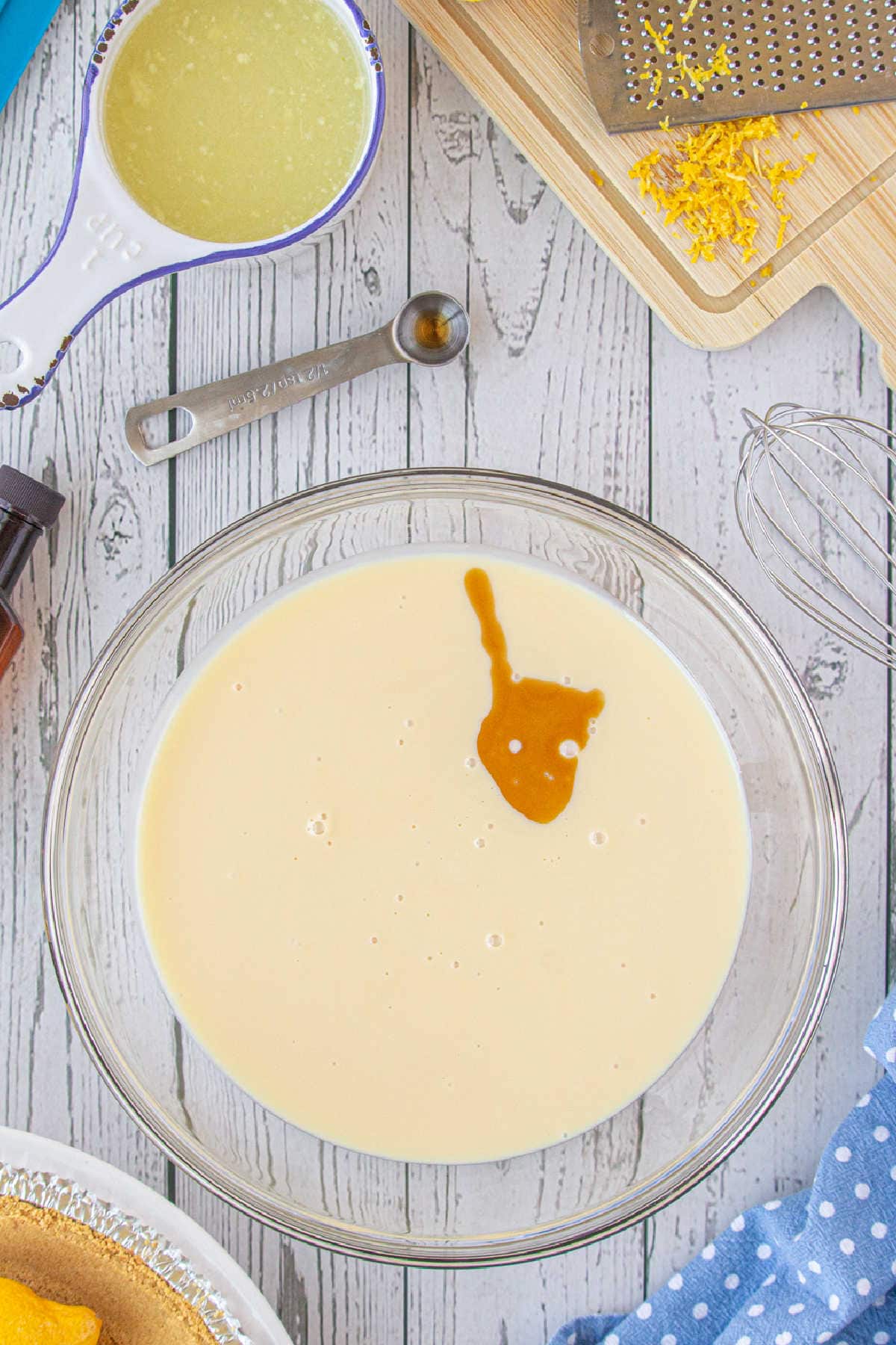 Vanilla added to sweetened condensed milk in a bowl.