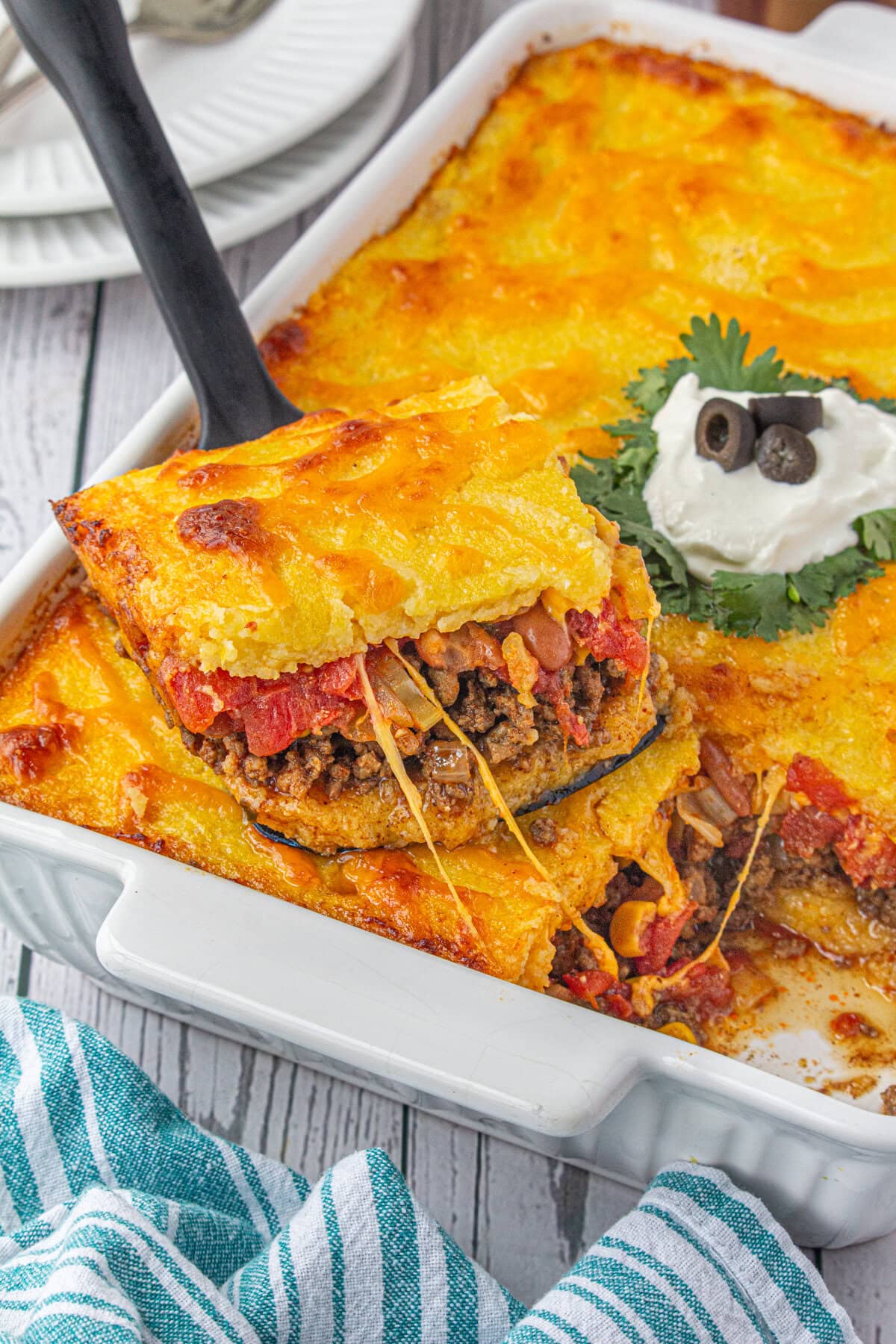 A serving of the cheesy tamale pie being removed from the pan.