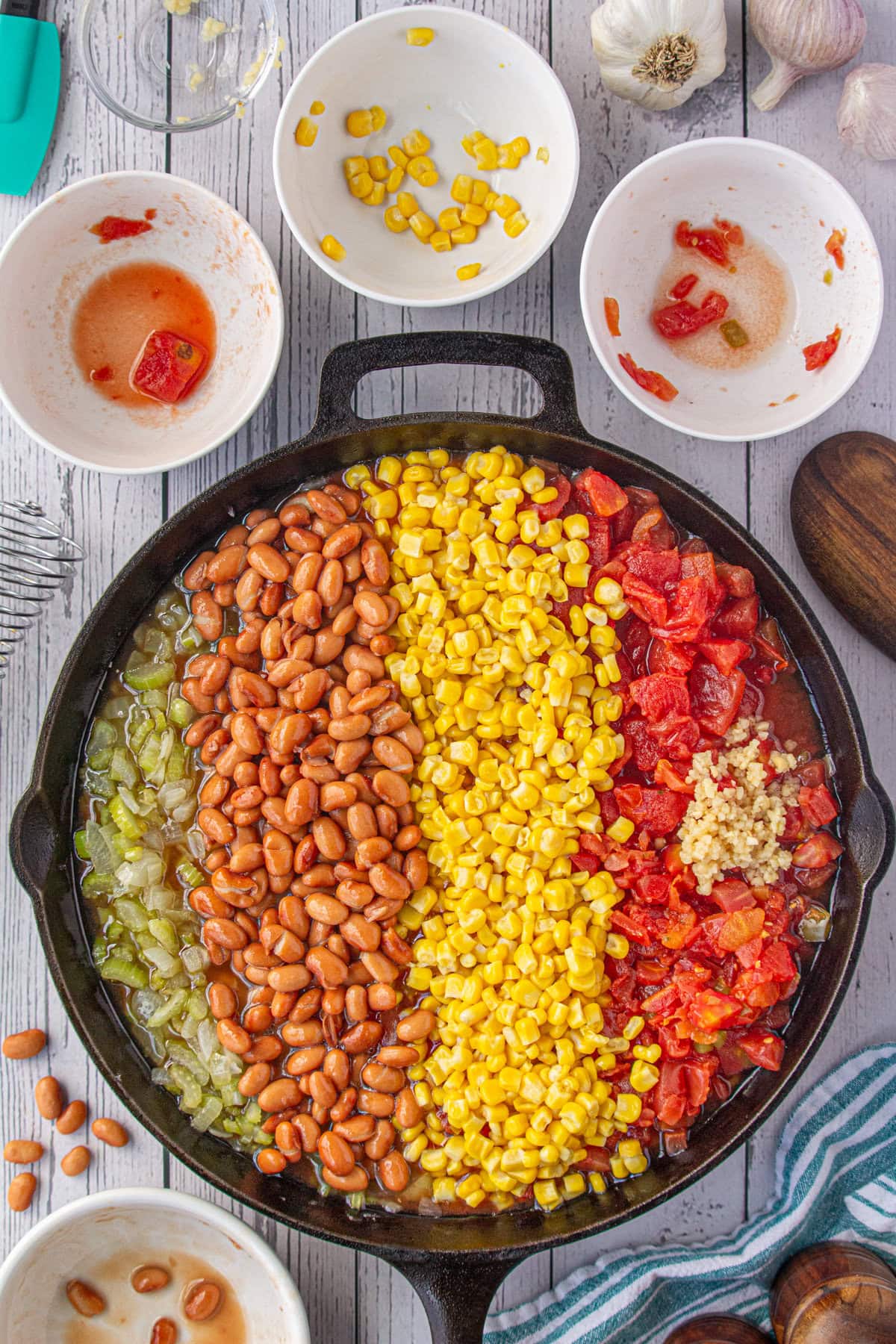 Beans, corn, tomatoes, and seasoning added to the cooked onion mixture.