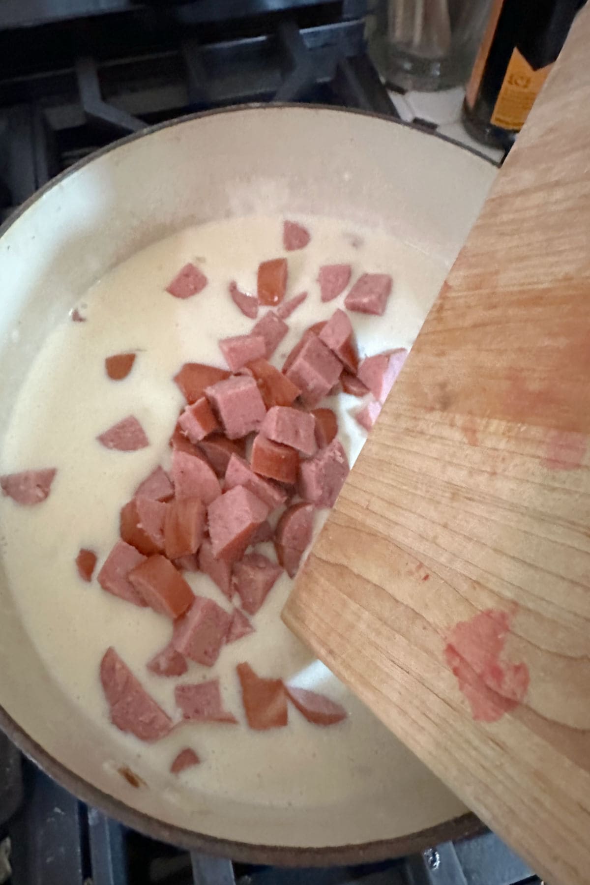 Adding the smoked sausage to the soup.